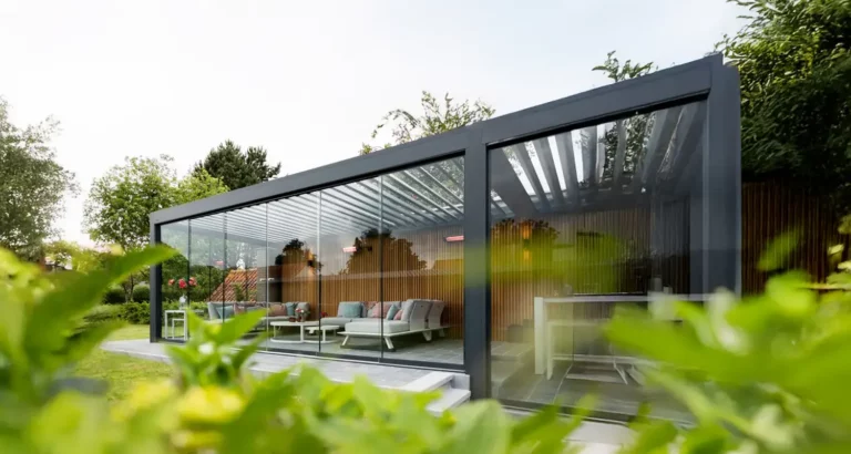 Moderne Terrassenüberdachung mit Glasdach und schwarzer Aluminiumkonstruktion im Garten